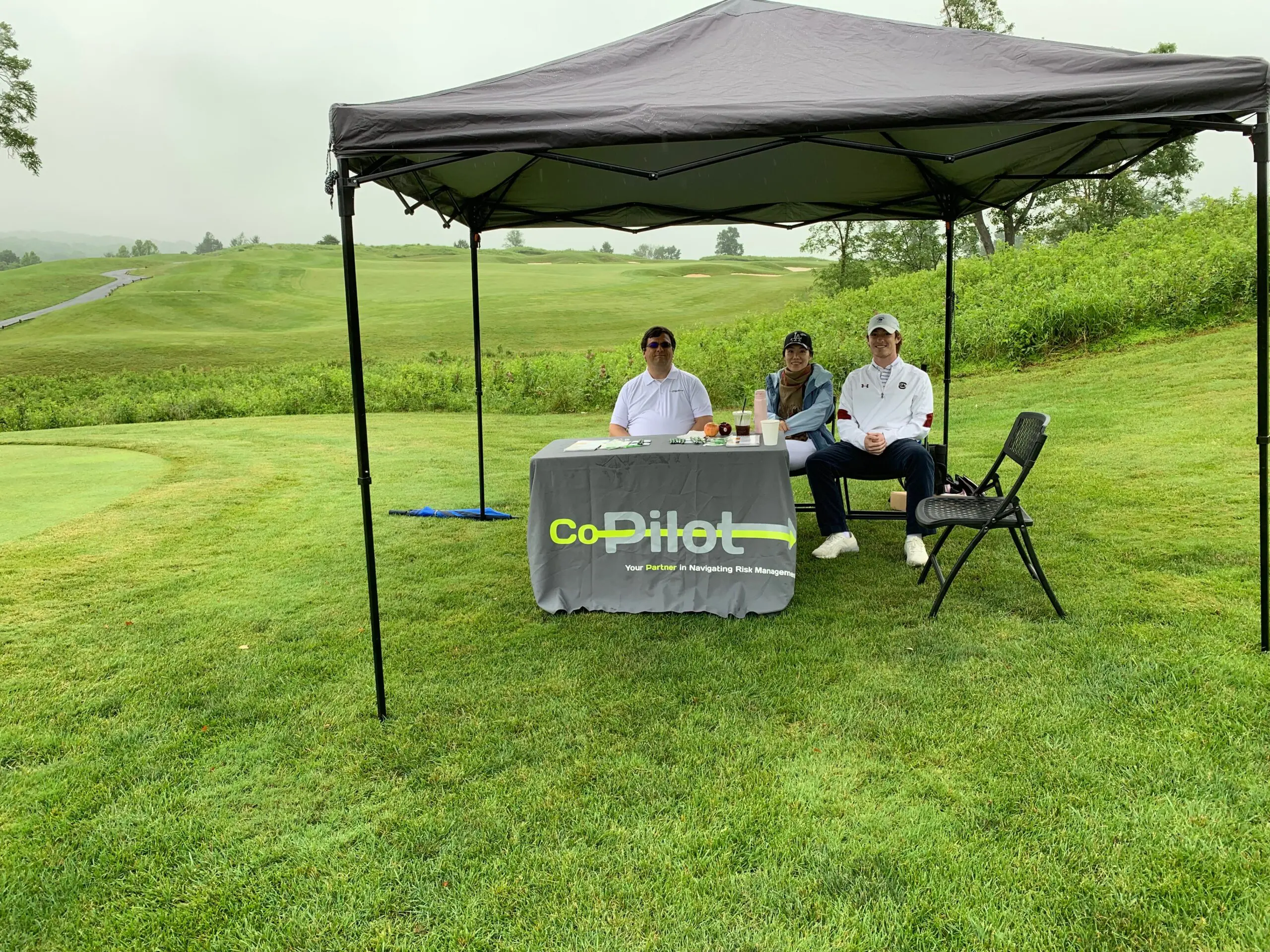 Golfers under canopy on lush course