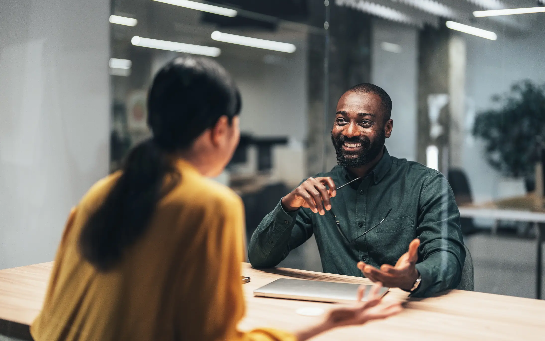A buyer consults with a landing specialist in a sleek, modern financial center. Ideal for illustrating mortgage consultations, real estate financing, or buyer support services in the financial industry.